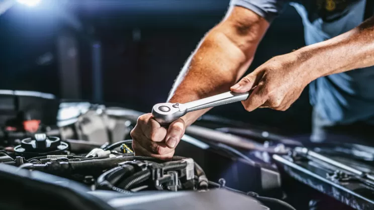 Meccanico al lavoro su motore auto